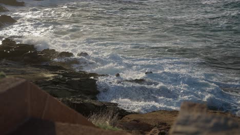 Olas-Brillantes-Que-Se-Estrellan-Contra-La-Costa-Rocosa-Durante-La-Puesta-De-Sol-De-La-Hora-Dorada-Olas-Espumosas