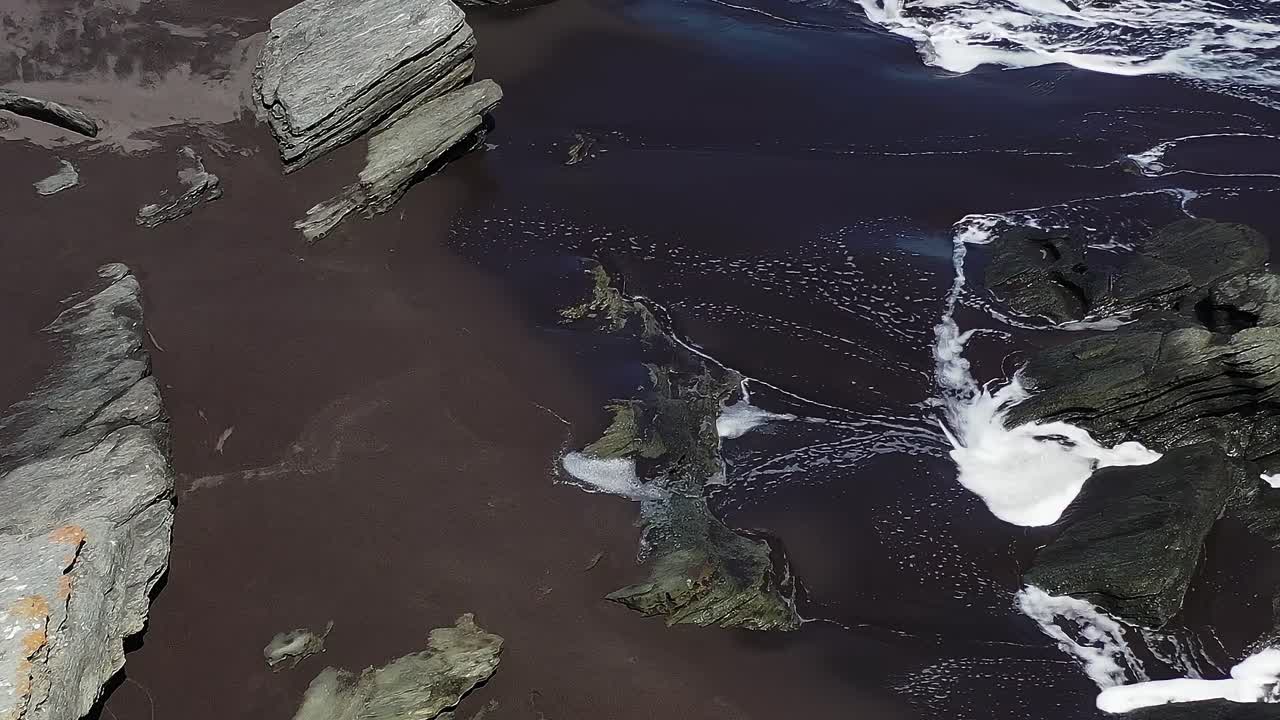 Waves crash on rocky shore in Chile during daylight