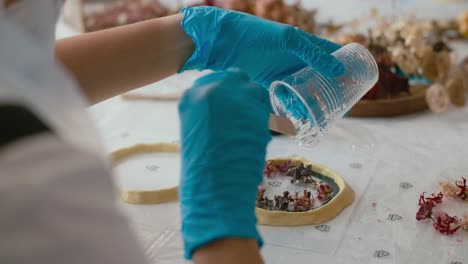 person making resin crafts with dried flowers
