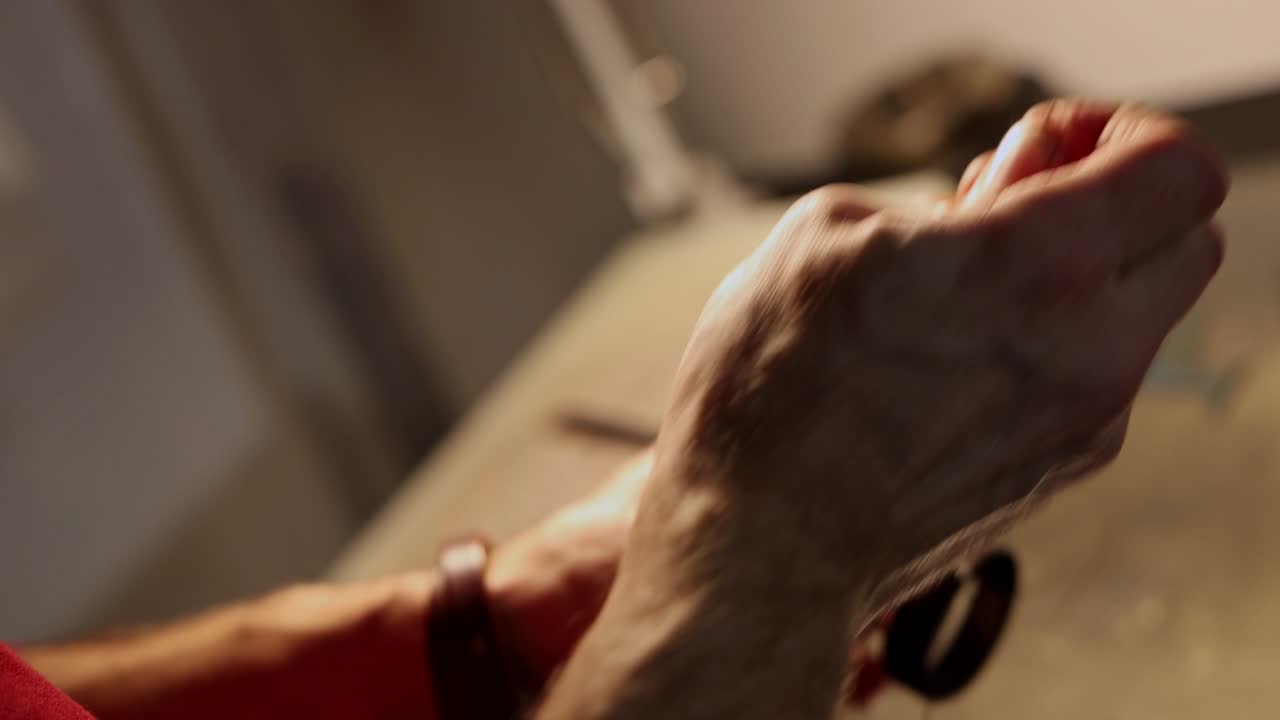 taller de cuero - un hombre cosía un pequeño bucle de cinturón