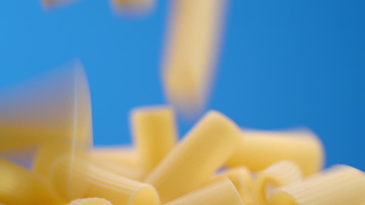 la pasta seca de cannelloni cae sobre la mesa en un montón.