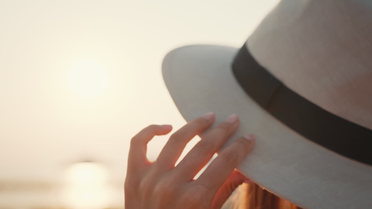 mujer con un sombrero al atardecer