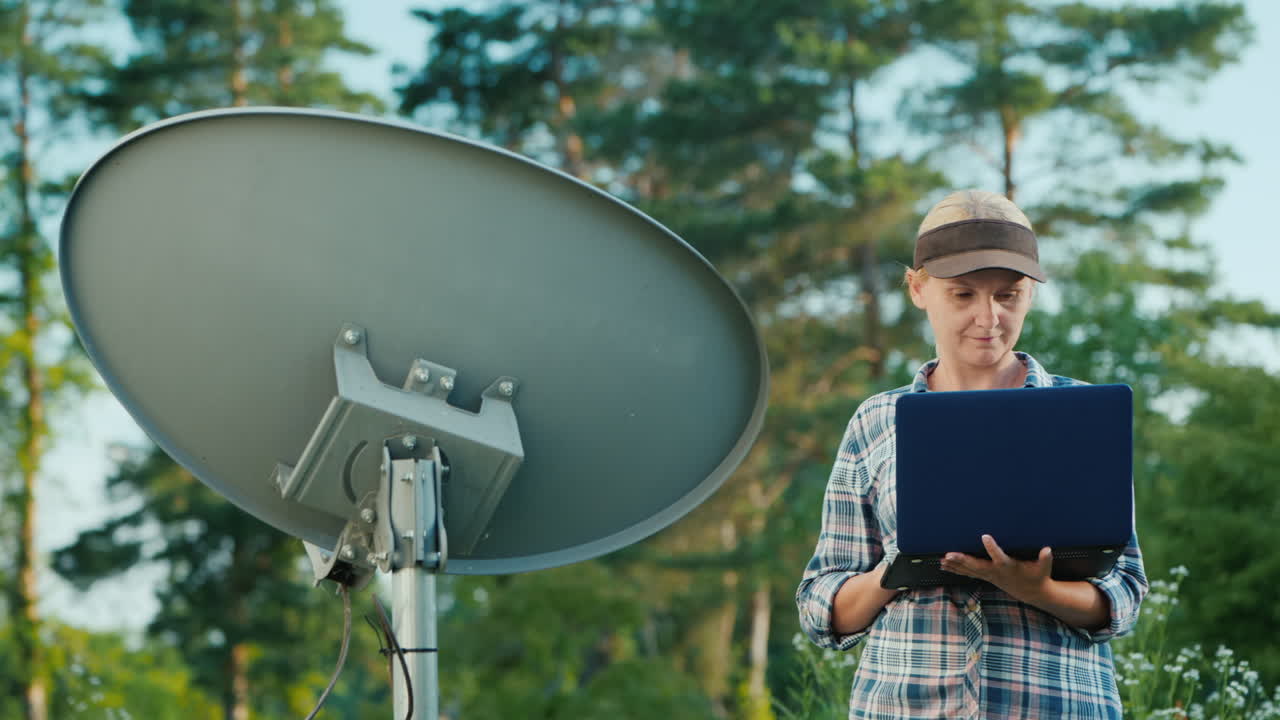 técnico configura una antena parabólica terrestre utiliza una computadora portátil