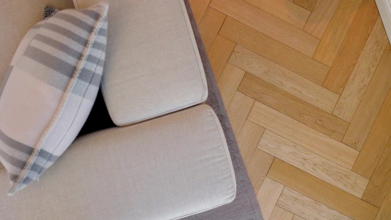 Camera rotates clockwise over a pale sofa and chevron parquet in La Rochelle