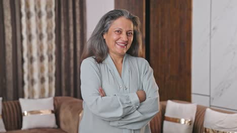 happy and confident indian businesswoman standing crossed hands