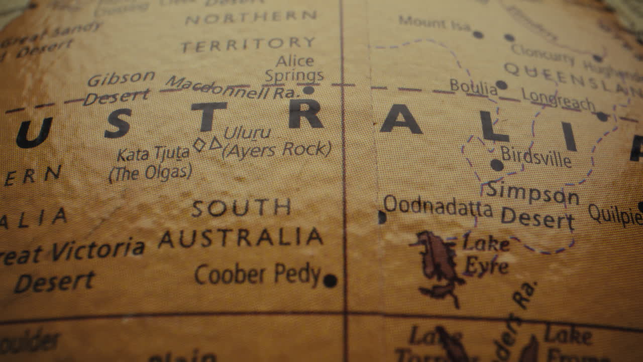 Close-up of a vintage world map, focusing on Australia and its deserts.
