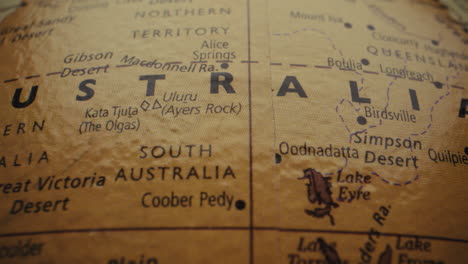 close-up of a vintage world map, focusing on australia and its deserts.
