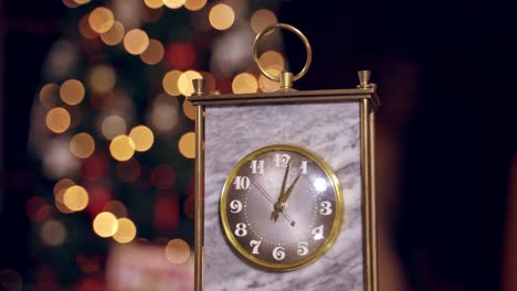 golden clock showing one hour. beautiful old clock on blurred christmas background. close-up.