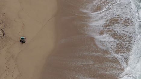 two girls looking at the waves on the beach