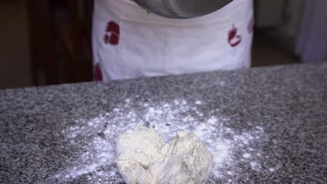 pastry chef taking mixed dough ingredients out of bowl ready for kneading