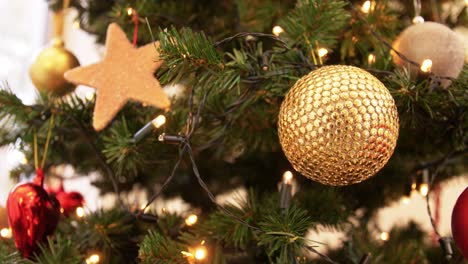 Goldene-Weihnachtskugeldekoration-Auf-Tannenbaum.Feiertage,-Neujahr-Und-Festkonzept-–-Goldene-Weihnachtskugeldekoration-Mit-Funkelnden-Girlandenlichtern-Auf-Künstlichem-Tannenbaum