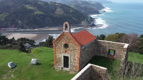 aerial drone view of a hermitage next to the cantabrian sea in deba in the basque country