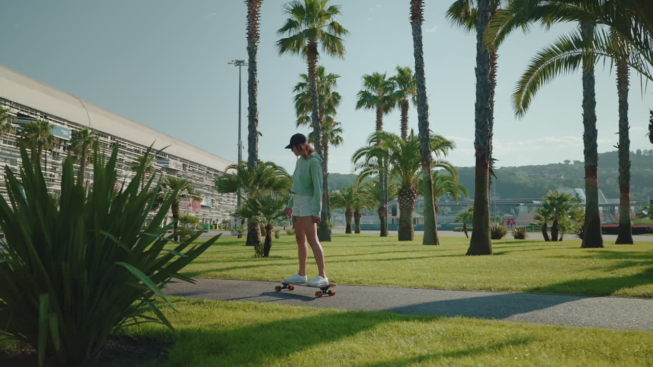 Woman Skateboarding in a City Park with Palm Trees