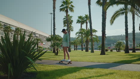 woman skateboarding in a city park with palm trees