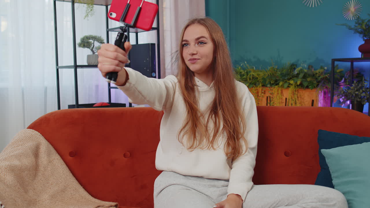 blogger influyente tomando una selfie en su teléfono inteligente, hacer un video virtual de redes sociales en línea en casa
