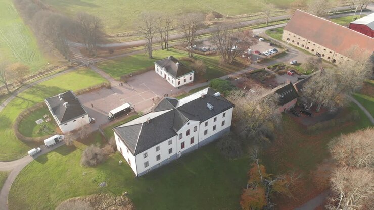 Sorvolo con drone di una grande casa di campagna bianca e dei suoi terreni con annessi