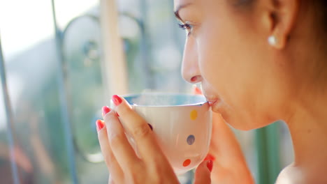 woman drinking coffee by the window