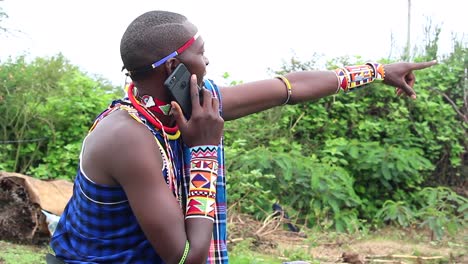 maasai man on phone pointing his finger at subject of interest