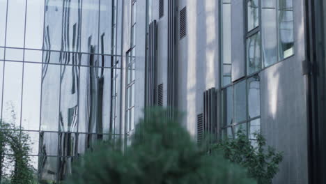 modern glass office building exterior. windows reflecting sky passing car.