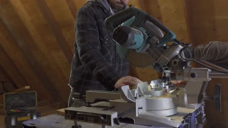 craftsman using a circular saw to cut metal in a woodworking workshop, with focus on the saw and hands