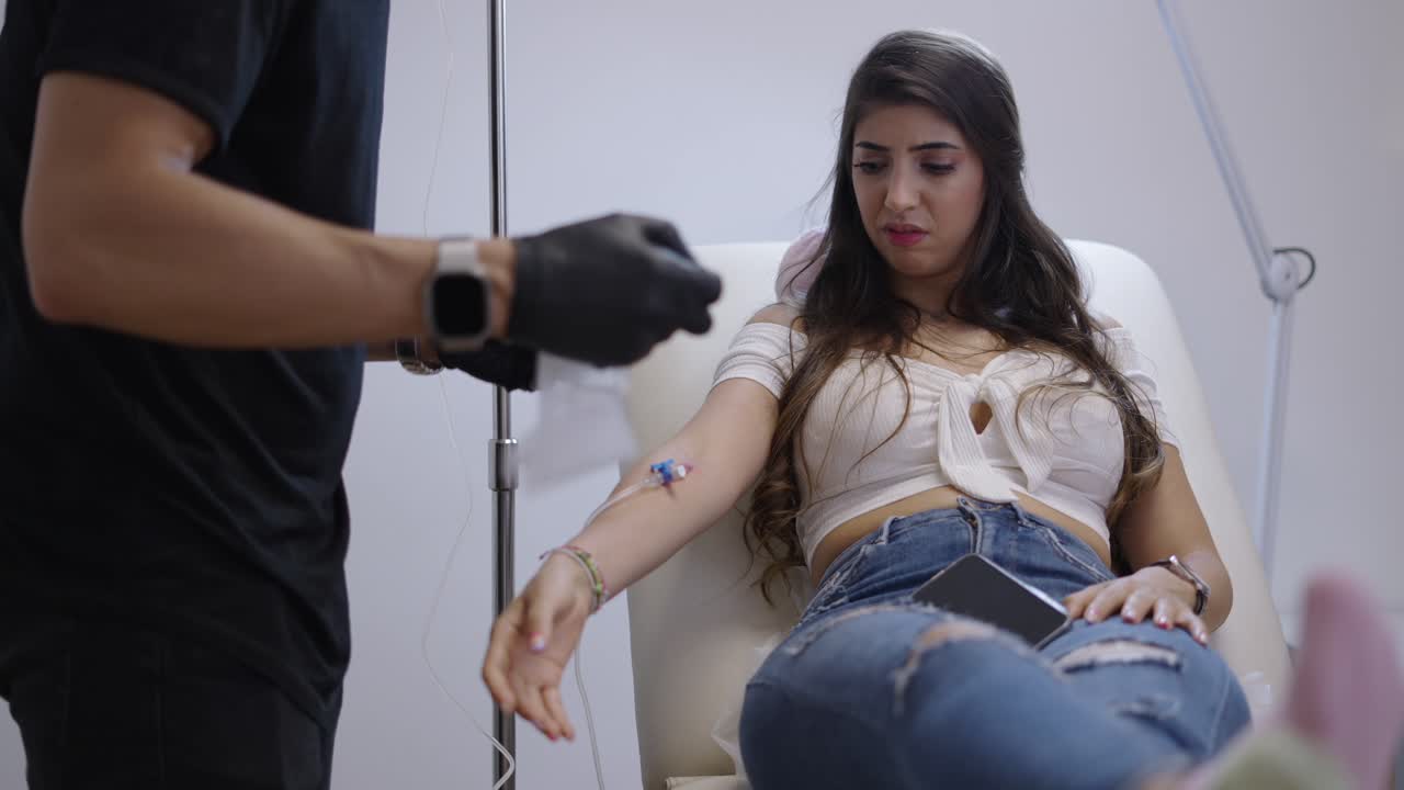 Woman receiving an intravenous (IV) drip in a clinic setting