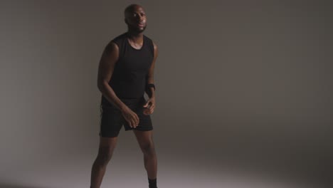 studio shot of male basketball player dribbling and passing ball to team mate 2