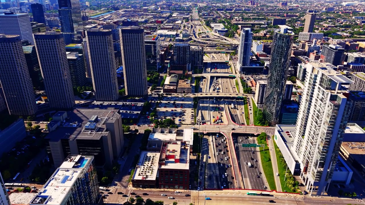 Aerial view of expressway interchange 90 near downtown Chicago, Illinois. Elevated drone shot of multilane highway ramps, traffic and residential towers beside a busy road junction.