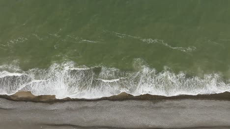 Luftaufnahme:-Das-Grüne-Meerwasser-Wäscht-Das-Ufer-Des-Strandes-Mit-Vielen-Kleinen-Kieselsteinen