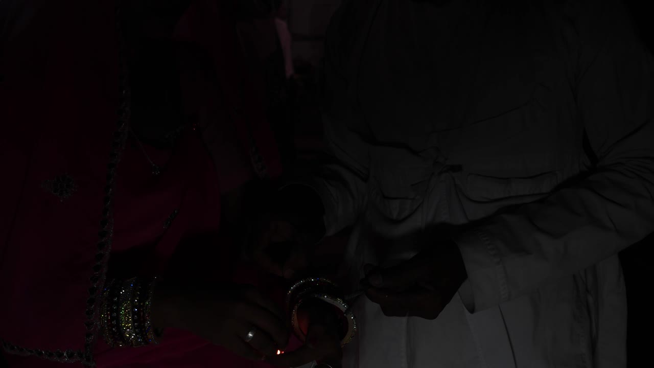 una pareja india en un vestido tradicional con una galleta brillante de fuego en el festival diwali mela en la india