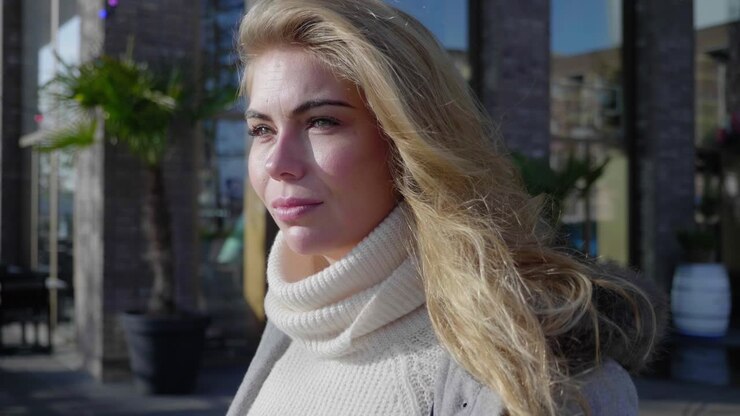 gros plan d'une jeune femme blonde à la grave, perdu dans ses pensées