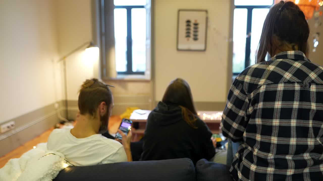 친구들이 집에서 함께 무언가를 보고 있습니다.