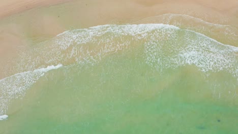 Blick-Von-Oben-Auf-Die-Meereswellen,-Die-Gegen-Einen-Wunderschönen-Strand-Schlagen