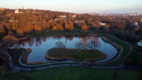 hermosos drones dispararon a personas caminando en un parque urbano con estanque en inglaterra