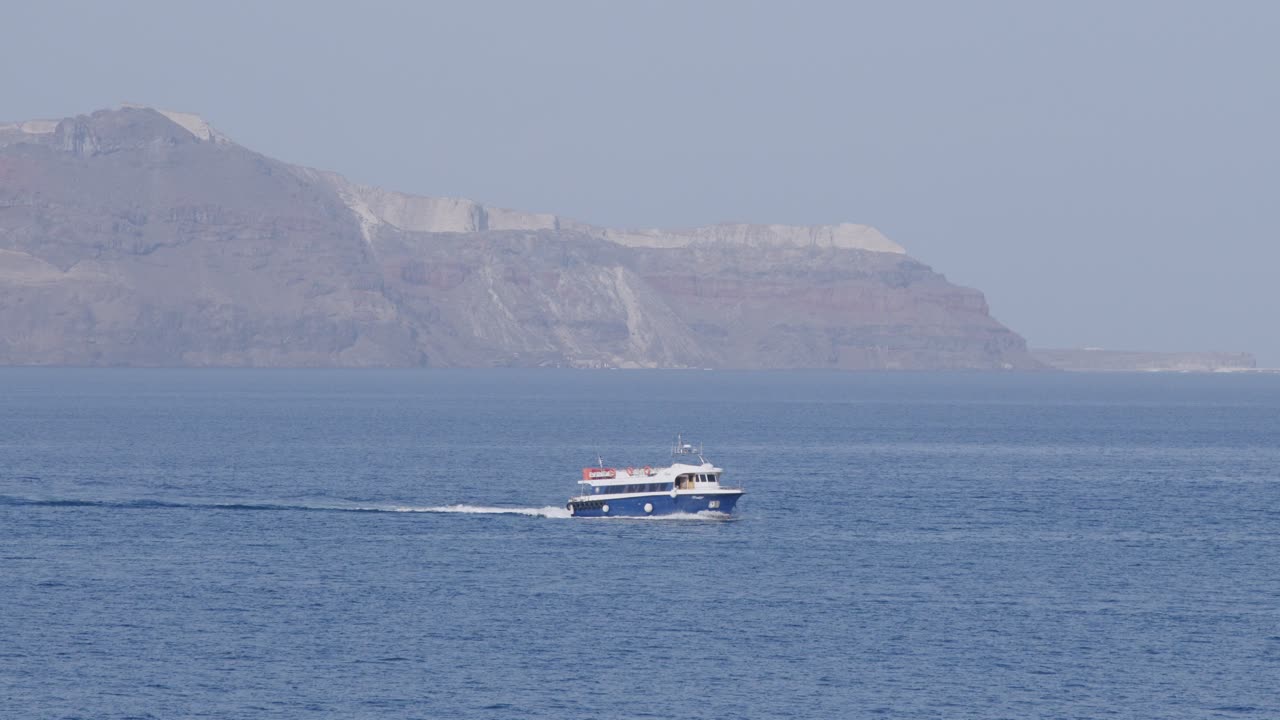 은 날 에 산토리니 의 피라 해안 근처 에서 항해 하는 여행 보트