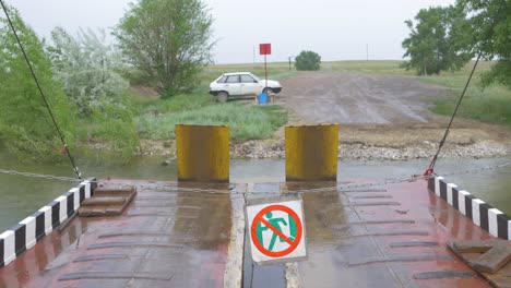 Ferry crossing a river on a rainy day with no pedestrian sign