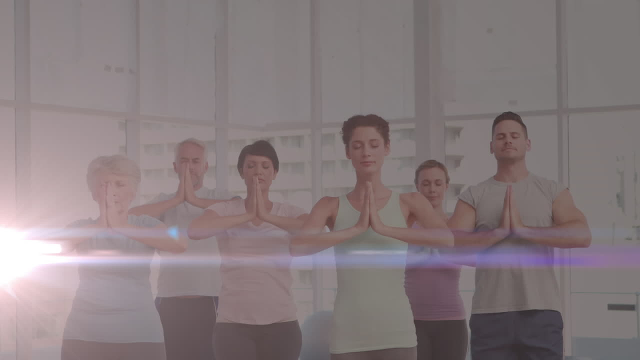 요가를 연습하는 사람들 위에 반이는 빛의 애니메이션