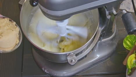 mixing sugar and butter together to start cookie dough on a medium speed