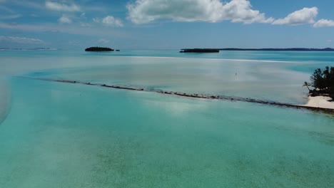 persona solitaria en una remota laguna tropical con pequeñas islas y palmeras tiro aéreo