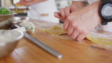 cocinera caucásica enseñando a un grupo diverso preparando platos y sonriendo
