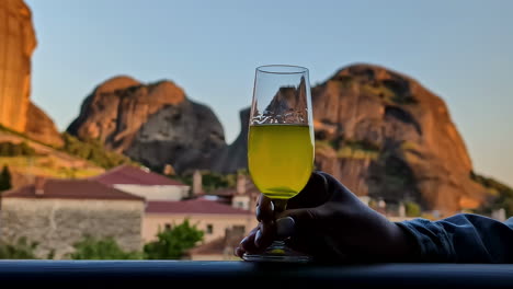 glass of drink with scenic mountain blurred background and clear sky