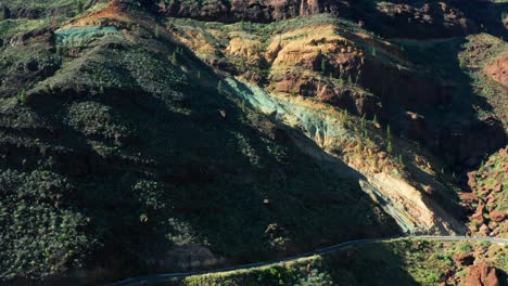 aerial orbit ascend of los azulejos de veneguera, mogan, capturing vibrant layered rocks in gran canaria, spain