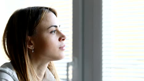young woman looking out of her office window