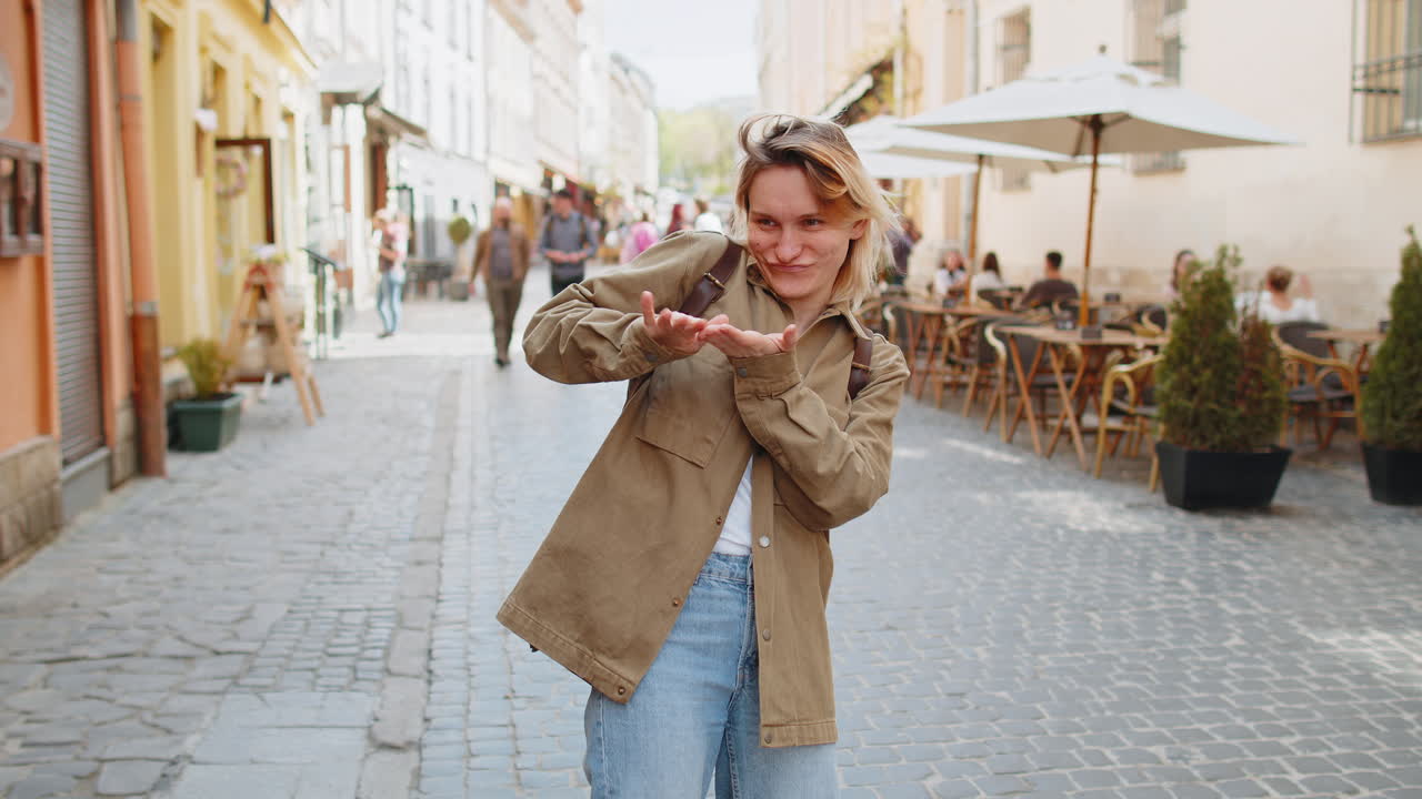 Cheerful rich woman tourist showing wasting throwing money around hand gesture share celebrate win