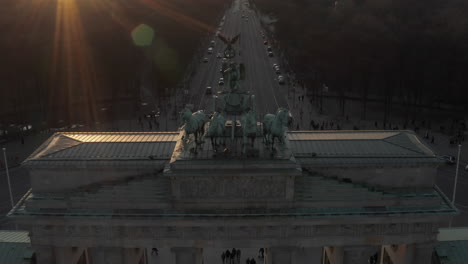 Antena:-Acercándose-Lentamente-A-La-Puerta-De-Brandenburgo-En-La-Hermosa-Luz-Del-Sol-Del-Atardecer-E-Inclinándose-Hacia-Abajo-En-La-Estatua-Verde-Quadriga-En-Berlín,-Alemania