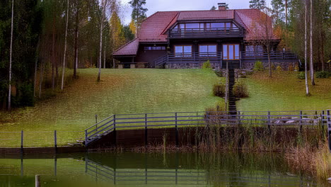 See-Oder-Teich-Im-Herbst,-Dann-Nach-Oben-Geneigt,-Um-Ein-Häuschen-Freizulegen-–-Wolkengebilde-Bewegung-Im-Zeitraffer