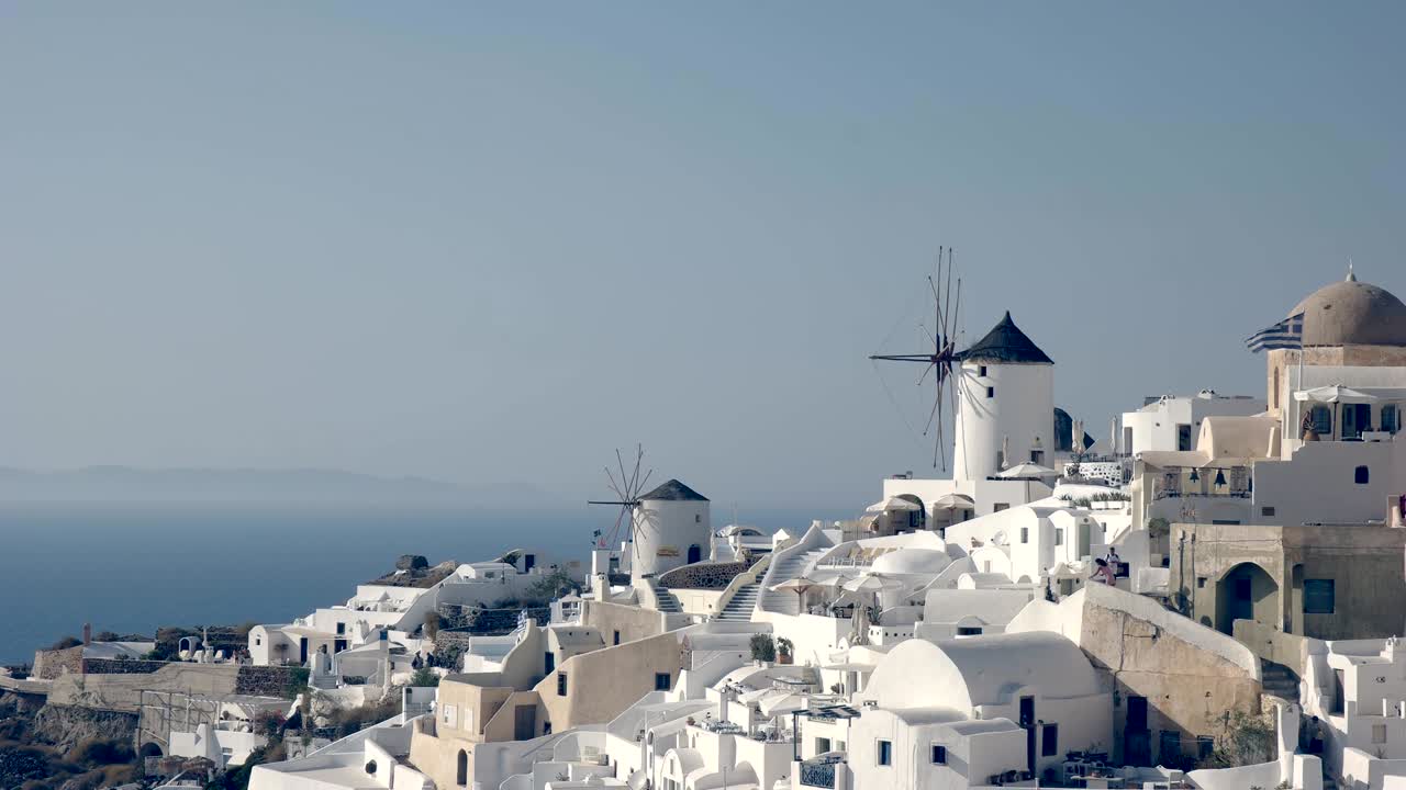 fotografía de la tarde de las casas blanqueadas y los molinos de viento en oia, santorini