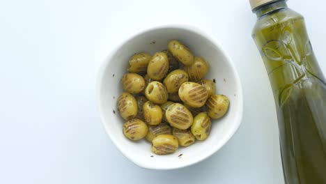 cuenco de aceitunas marinadas y botella de aceite de oliva