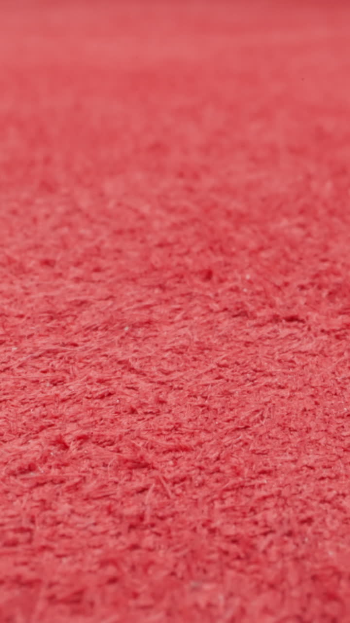 Textured surface of red cow leather material as background extreme close view. Sewing clothes and shoes in workshop. Design ideas and fashion