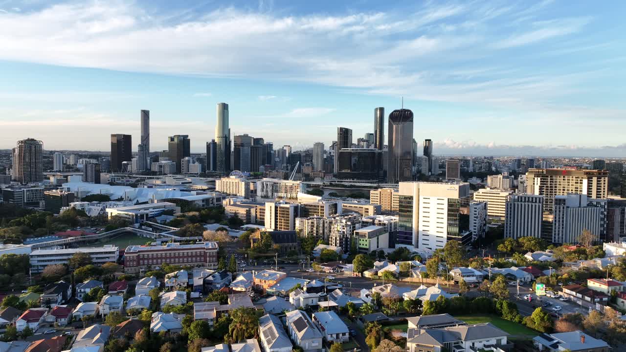 Lento tracciamento laterale con drone all'ora d'oro sopra Highgate Hill e West End, che rivela l'intera skyline del CBD di Brisbane con le torri di Queens Wharf in lontananza, Brisbane, QLD, Australia.