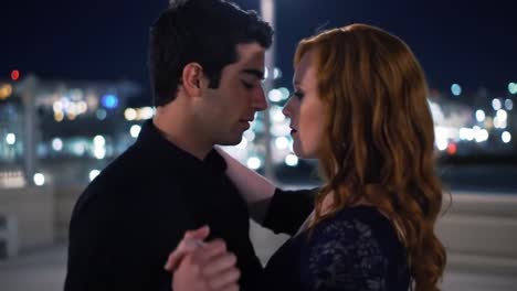 A Romantic Dance Under City Lights: A Captivating Moment Between Two Lovers Embracing Their Feelings in a Nighttime Setting Filled with Soft Illumination